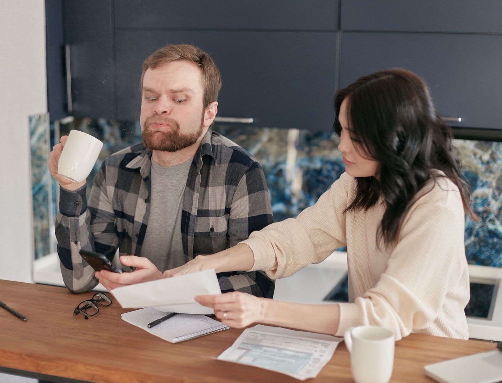 Couple reviewing bills at their kitchen table